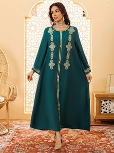 Détails de broderies dorées et de boutons sur une robe abaya ethnique vert foncé élégante