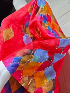 Detail of elegant V-neck dress with colorful leaf print and sparkling rhinestones
