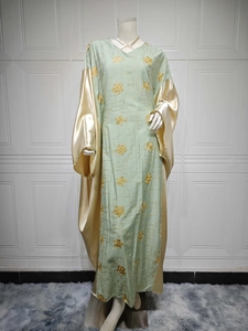 Close-up of mint green Abaya with gold floral embroidery and satin flare sleeves