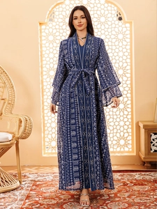 Détail d'une robe en maille brodée bleu marine avec motifs géométriques et manches évasées