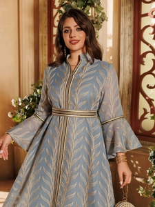 Detail of bell sleeves and golden leaf patterns on a blue elegant embroidered maxi dress