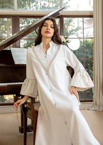 Close-up of white dress with silver lace V-neck embroidery and floral flared cuffs