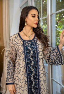 Exquisite blue sequin and bead embroidery detail on a beige mesh kaftan dress