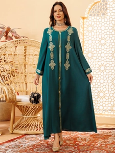 Détail des broderies géométriques dorées sur une robe abaya ethnique vert foncé