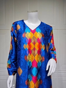 Detail of royal blue V-neck dress with colorful geometric patterns and rhinestones