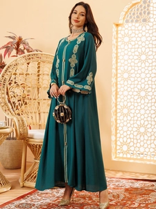 Détail de la broderie géométrique dorée sur robe caftan ethnique vert foncé à manches