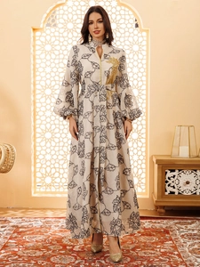 Close-up of golden floral embroidery and leaf pattern on a cream Jalabiya dress