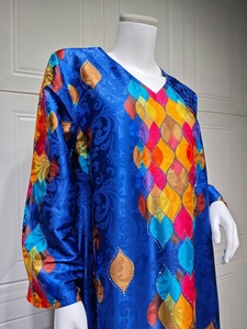 Detail of V-neck long sleeve satin kaftan dress with colorful leaf prints and rhinestones