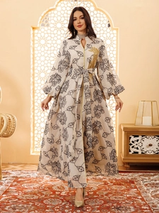 Detail of gold sequin embroidery on cream Jalabiya dress with black leaf pattern