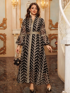 Close-up of golden embroidery and woven belt on elegant black Kaftan maxi dress