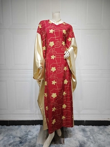 Close-up detail of golden embroidery and satin sleeve on red bohemian kaftan dress