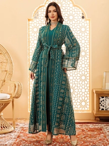 Détails de broderie dorée et dentelle sur une robe caftan élégante en maille vert émeraude