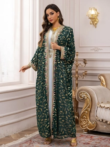 Détail de l'Abaya émeraude avec motifs de plumes dorées et bordure géométrique