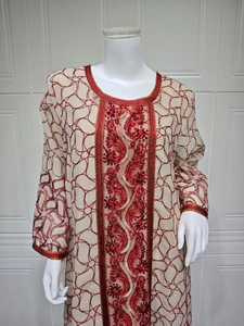 Detailed close-up of intricate gold and red sequin embroidery on mesh dress
