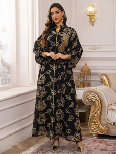 Detail of black jalabiya abaya with intricate gold leaf embroidery and zip front closure