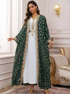 Détail de l'abaya en mousseline vert foncé avec imprimés plumes dorées et dentelle tissée