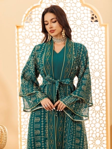 Détail d'un élégant caftan vert foncé avec broderie dorée et manches évasées fluides