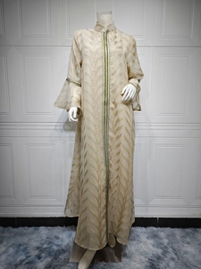 Detail of champagne embroidered long dress with gold leaf patterns and bell sleeves