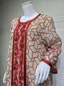 Detailed close-up of red sequin embroidery and ethnic patterns on mesh dress