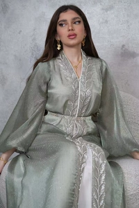 Detail of light green modest dress with silver leaf embroidery and sparkling texture