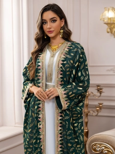Détail des paillettes dorées et broderies ethniques sur robe en mousseline verte