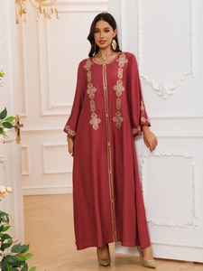Détails de broderie dorée sur robe longue ethnique bordeaux avec boutons dorés