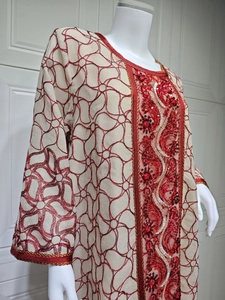 Close-up of red sequin embroidery and intricate golden trim on the mesh dress