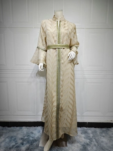 Detail of champagne kaftan with golden leaf embroidery and ethnic ribbon trim on sleeves