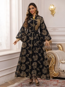 Detail view of ornate gold leaf embroidery and bird motif on black Jalabiya dress