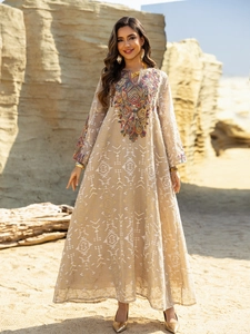 Detail of ethnic embroidery on light beige mesh maxi dress in a desert setting