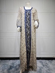 Detail view of the intricate blue embroidery and shimmering sequins on the beige mesh abaya