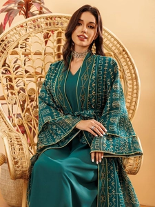 Détail d'une abaya vert émeraude avec broderies de feuilles dorées sophistiquées