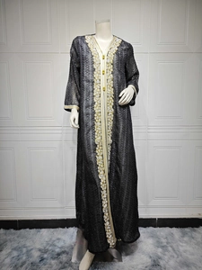 Detailansicht einer eleganten schwarzen Abaya mit Goldstickerei und Perlenverzierung