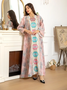 Détails de broderie et motifs ethniques sur une élégante robe longue rose à manches