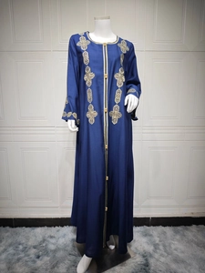 Détail d'une robe maxi bleu marine avec broderies dorées sur le col et les poignets