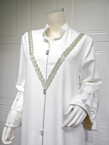 Detailed silver floral embroidery on white kaftan sleeves with elegant ethnic pattern