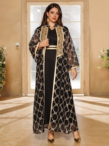 Detail einer schwarzen Abaya mit aufwendiger goldener Stickerei und Kettenmuster