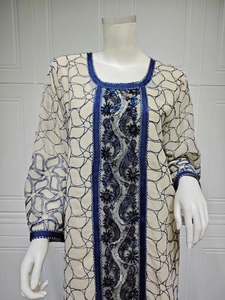 Close-up of sequin embroidery and navy vine patterns on beige mesh dress bodice