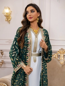 Détail de cafetan en mousseline émeraude avec motifs plumes dorées et broderies ethniques