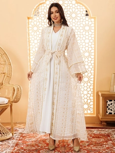 Détail d'un caftan blanc élégant avec broderie dorée et manches évasées fluides
