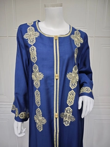 Détail d'un caftan bleu marine avec broderie dorée et fermeture à boutons grenouille