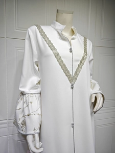Detail of white Abaya featuring silver embroidered V-neckline and bell sleeve cuffs