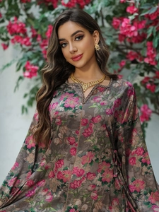 Detailed close-up of a floral printed kaftan dress with V-neckline and gold jewelry set