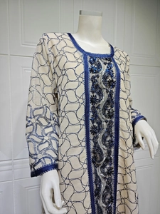 Detailed view of blue ethnic sequin embroidery and beadwork on beige mesh maxi dress