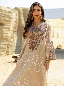 Close-up of vibrant embroidery and beadwork on a beige ethnic kaftan dress
