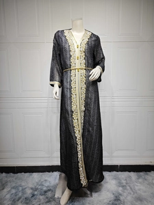 Detailansicht eines schwarzen langen Sommerkleids mit Goldstickerei und Strass.