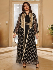 Detail eines schwarzen Abaya-Sets mit feiner goldener Stickerei und Perlenhandtasche