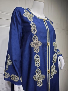 Détail du caftan bleu marine montrant des broderies dorées et des boutons boules
