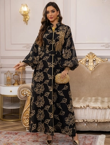 Detail of black chiffon abaya dress with golden leaf embroidery and lantern sleeves