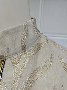 Close-up of elegant embroidery on the stand collar of this beige flare sleeve maxi dress